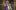 Frog Princess-2019-7 A Black woman wearing a crown and purple and gold royal garb looks excited with her hands in fists close to her chest.